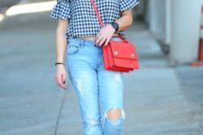 With distressed jeans, black mules and red bag