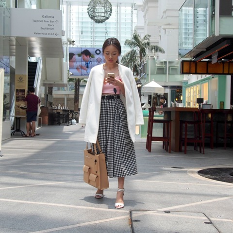 With pink crop top, white long blazer, white sandals and beige tote