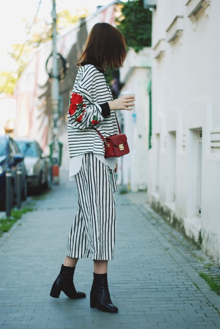 With striped loose shirt, black ankle boots and red mini bag