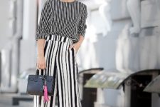 With striped shirt, white sandals and black mini bag