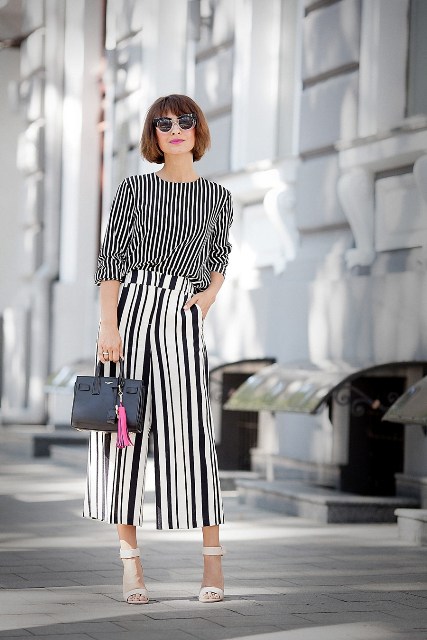 With striped shirt, white sandals and black mini bag