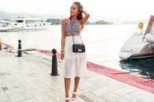 With white airy skirt, white sandals and black chain strap bag
