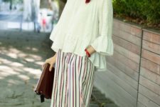 With white loose ruffle shirt, hat, beige sandals and clutch