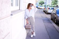 With white shirt, white sneakers and beige bag