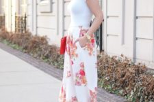 With white t-shirt, beige sandals, hat and red clutch