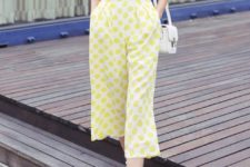 With yellow and white polka dot culottes, white shoes and white bag