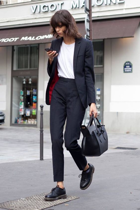 a black pantsuit with an oversized jacket, a white tee and flat shoes for a Parisian chic feel