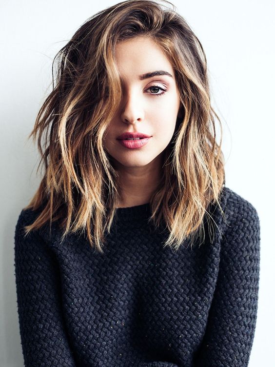 a chic long bob haircut with messy waves, a side parting and balayage