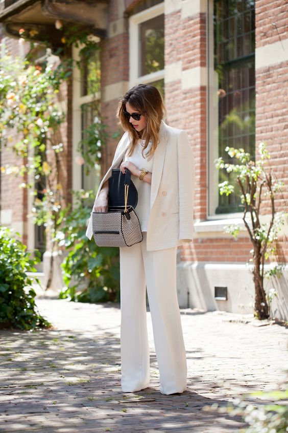 a creamy wide leg pantsuit, a white top and a printed bag for a luxurious feel