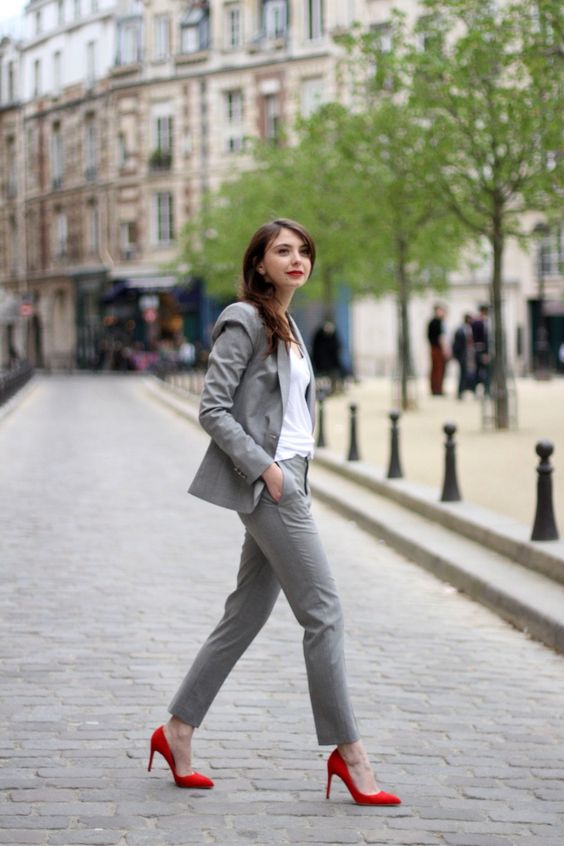 a grey suit, a white top and red pumps for a colorful touch