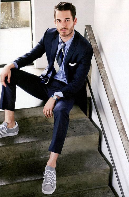 05 a navy suit a light blue shirt a striped tie and grey sneakers for a relaxed touch