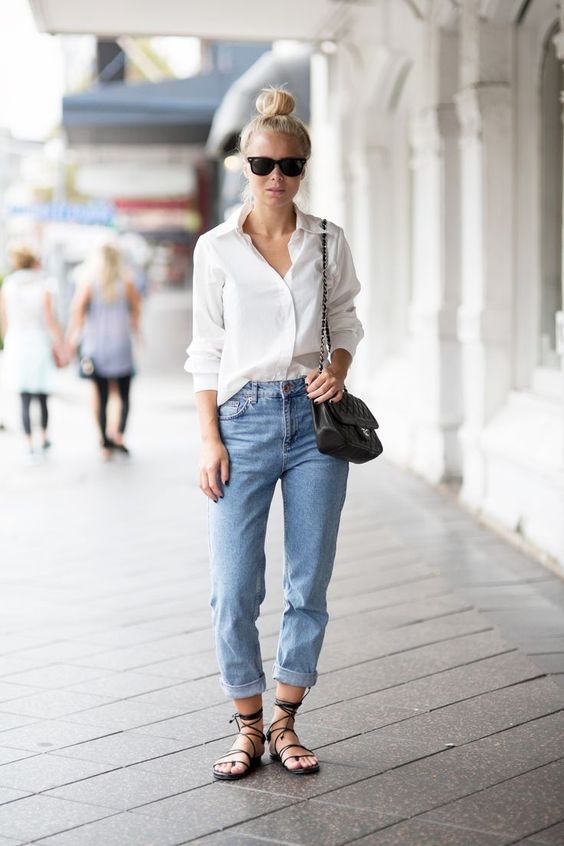 a white button down blue cuffed jeans, black lace up sandals and a black bag