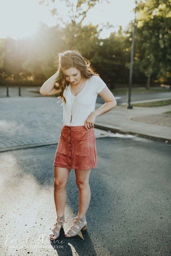a white tee, a rust-colored suede button down skirt and grey lace up shoes