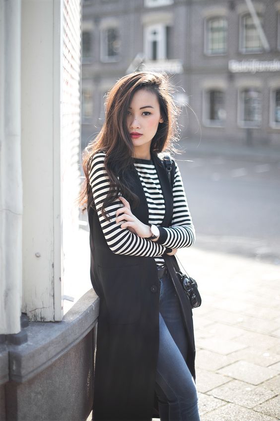 navy skinnies, a striped long sleeve top, a black long vest for a business casual look