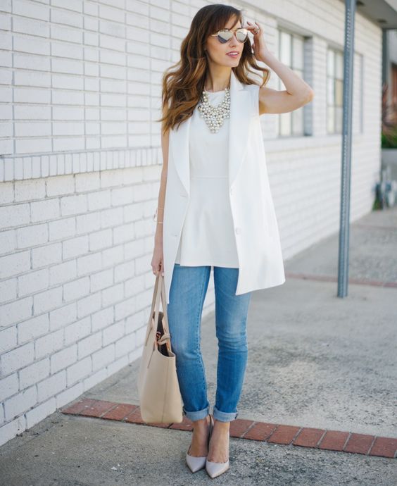 blue skinnies, a white top, a white long vest, layered necklaces and white shoes for a clean look
