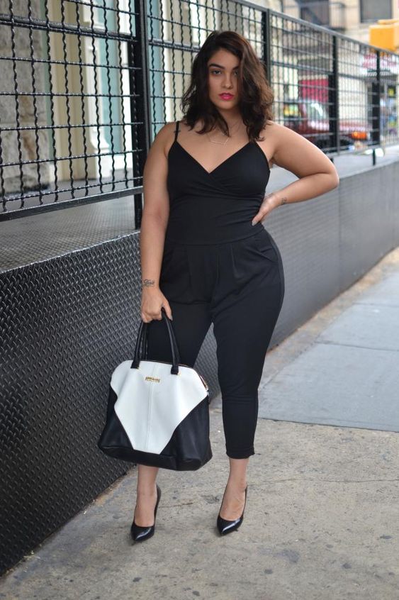 a black jumpsuit with spaghetti straps, cropped pants, blakc shoes and a black and white bag
