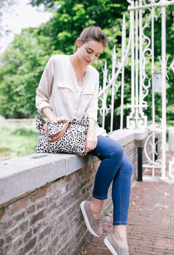 a creamy button down, blue skinnies, grey slipons for a printed bag for a casual Friday look