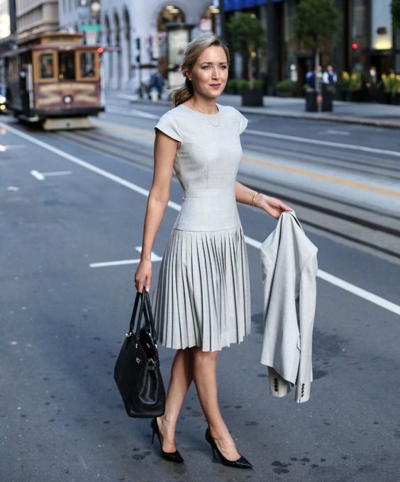 a light grey A-line dress with cap sleeves, a pleated skirt and a macthing jacket