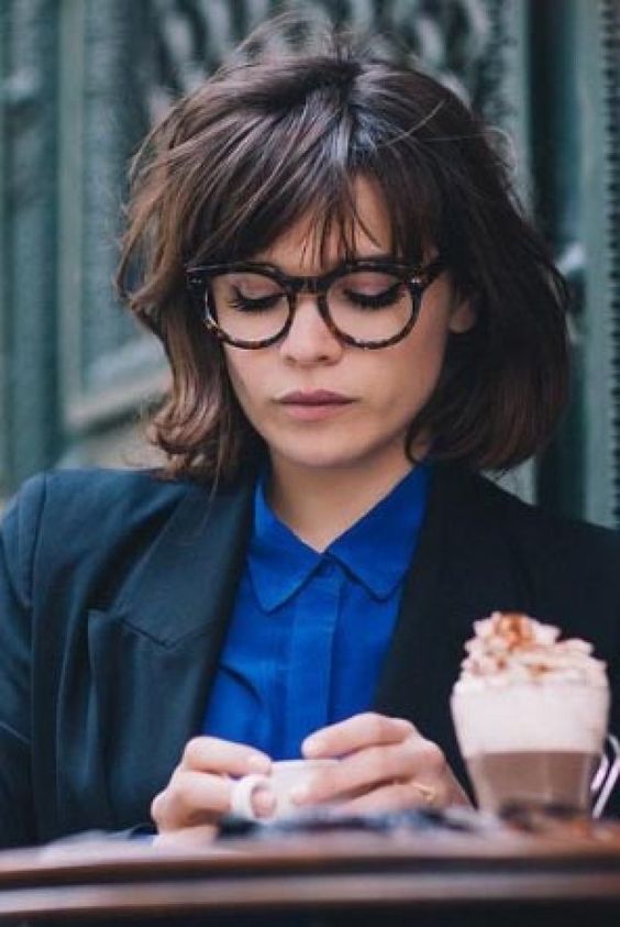 a short messy bob worn with a long French fringe and trendy glasses