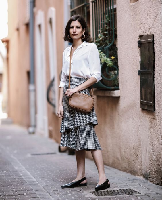 a white button down, a ginghm ruffle skirt, black flat shoes and a brown bag