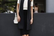 16 a black midi skirt, a white tee, a black long vest and flat shoes for a minimalist look
