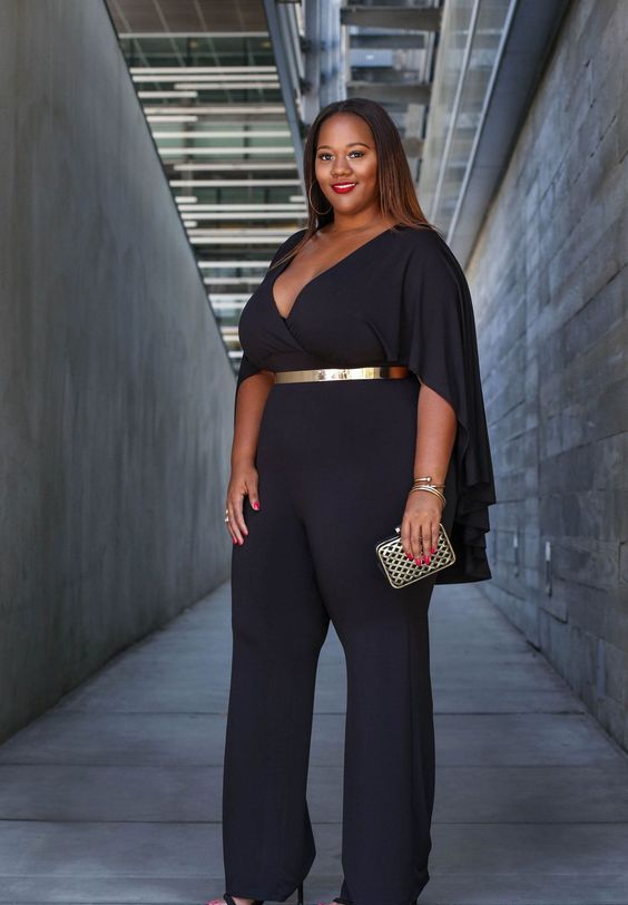 a chic black jumpsuit with a deep V-neckline, cape-like sleeves and a metallic belt