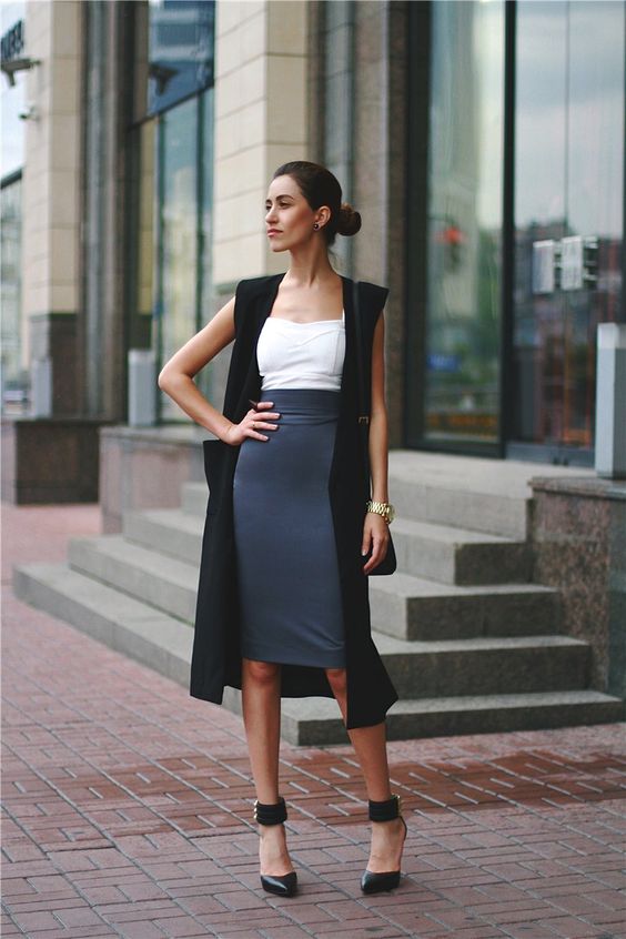 a grey midi knee pencil skirt, a white top, a long black vest and black ankle stap shoes