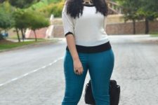 16 turquoise pants, a white and black top, a black bag and black shoes for a colorful touch
