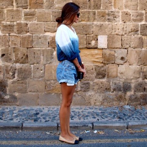 With denim shorts, clutch and two colored flats