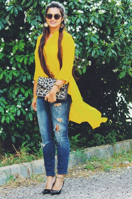 With distressed jeans, black pumps and leopard clutch