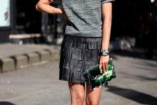 With gray shirt, sneakers and green clutch