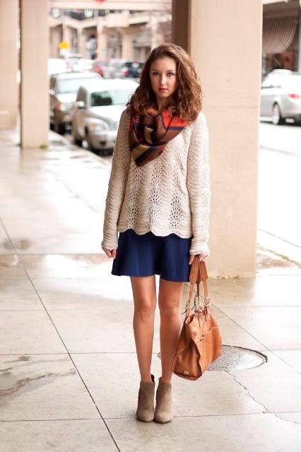 With navy blue skirt, printed scarf, gray ankle boots and brown bag