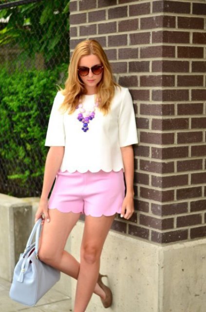 With pink shorts, beige pumps and light blue bag