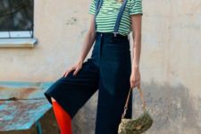 With striped shirt, red socks, green sandals and printed small bag