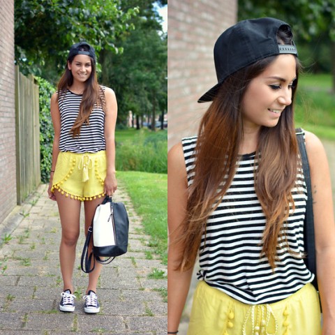 With striped top, black cap, sneakers and black and white backpack