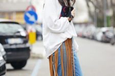 With white loose shirt, jeans and printed clutch