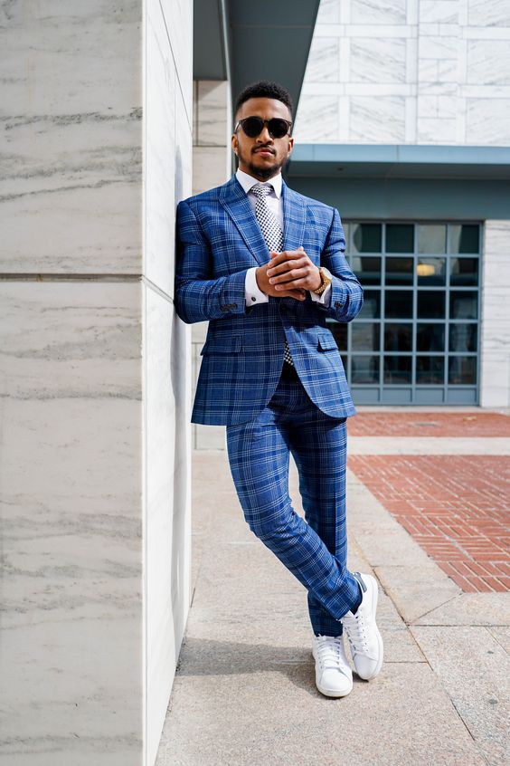 a bold and modern graduation look with a blue checked pantsuit, a white button down, a printed tie, white sneakers