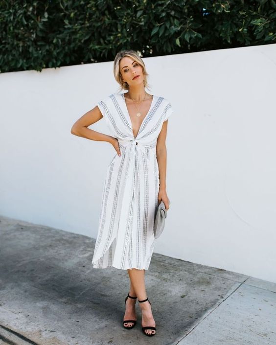 a cute grey and white striped dress with a plunging neckline and cap sleeves, black shoes and a clutch