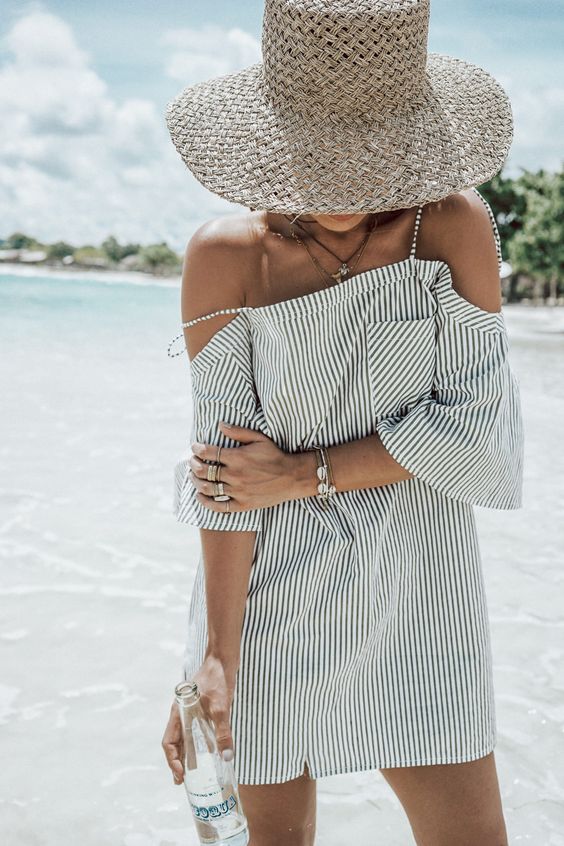 a striped black and white mini dress with a cold shoulder looks very beach-like