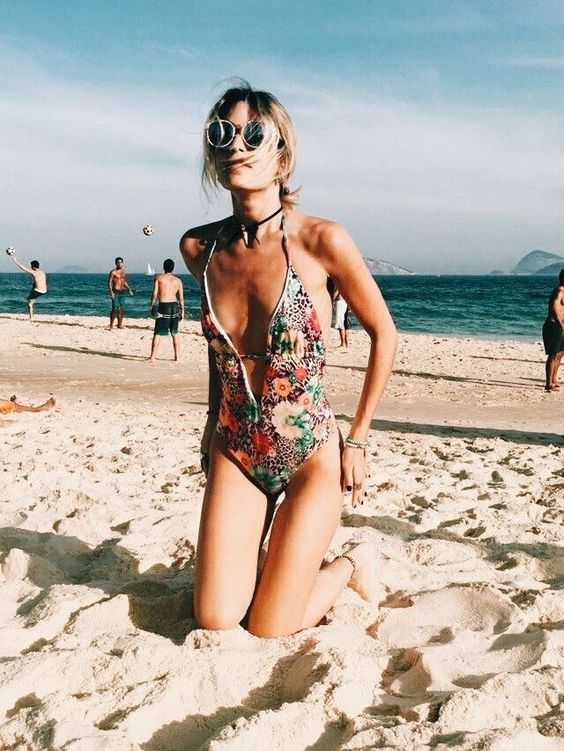 a vintage-inspired hippie one piece floral swimsuit with spaghetti straps and a plunging neckline