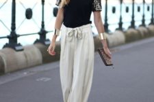 With black blouse, black pumps and printed clutch