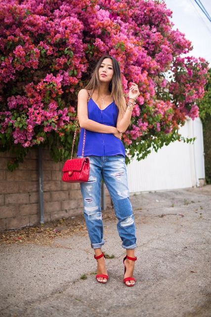 With distressed cuffed jeans, red sandals and red bag