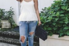 With distressed jeans, beige shoes and black bag