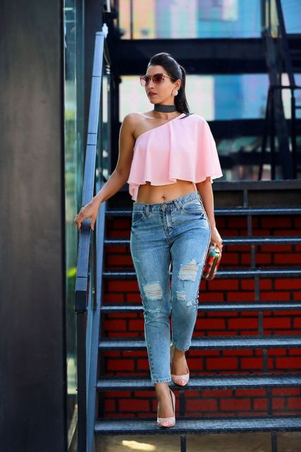 With distressed jeans, pale pink pumps and colorful clutch