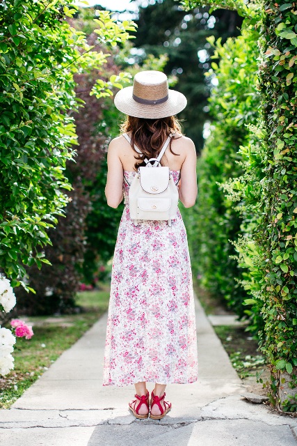 With floral maxi dress, wide brim hat and red sandals