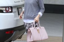 With floral pants, white shirt, gray sweatshirt and pale pink bag