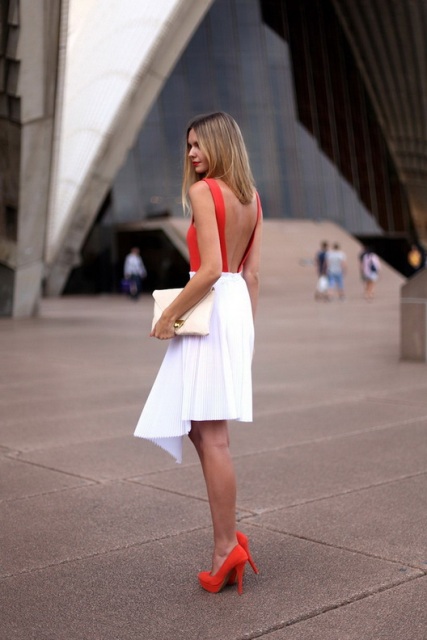 With white knee-length skirt, pastel colored clutch and red heels