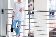 With white loose button down shirt, distressed jeans and black bag