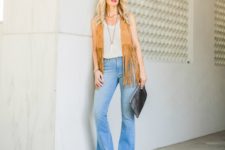With white top, flare jeans, platform shoes and black clutch