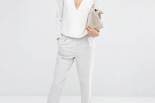 With white trousers, white sandals and beige clutch